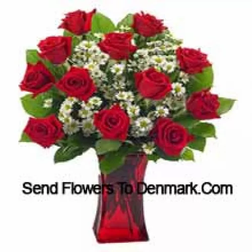 11 roses rouges avec quelques fougères dans un vase en verre