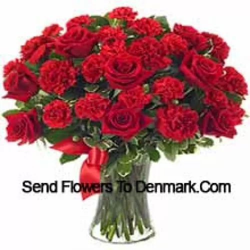 15 Red Roses And 10 Red Carnations With Some Ferns In A Glass Vase